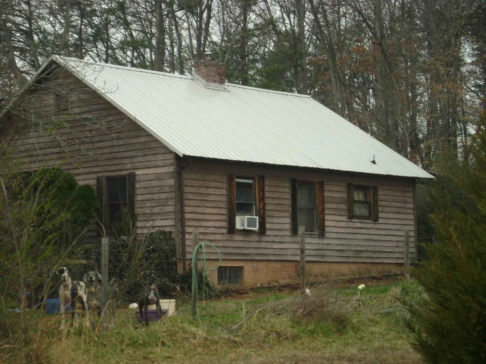 White metal roof on an old wood sided farmhouse, from a Metal Roof Installation job in Yoder